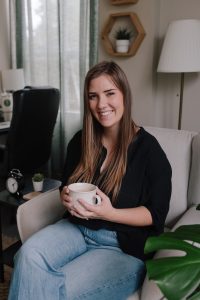 Amy Kobelt sitting with a cup of coffee in her counselling office in Vancouver BC providing clinical consultation to therapists 